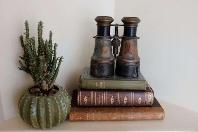 a stack of books sitting on top of a white shelf