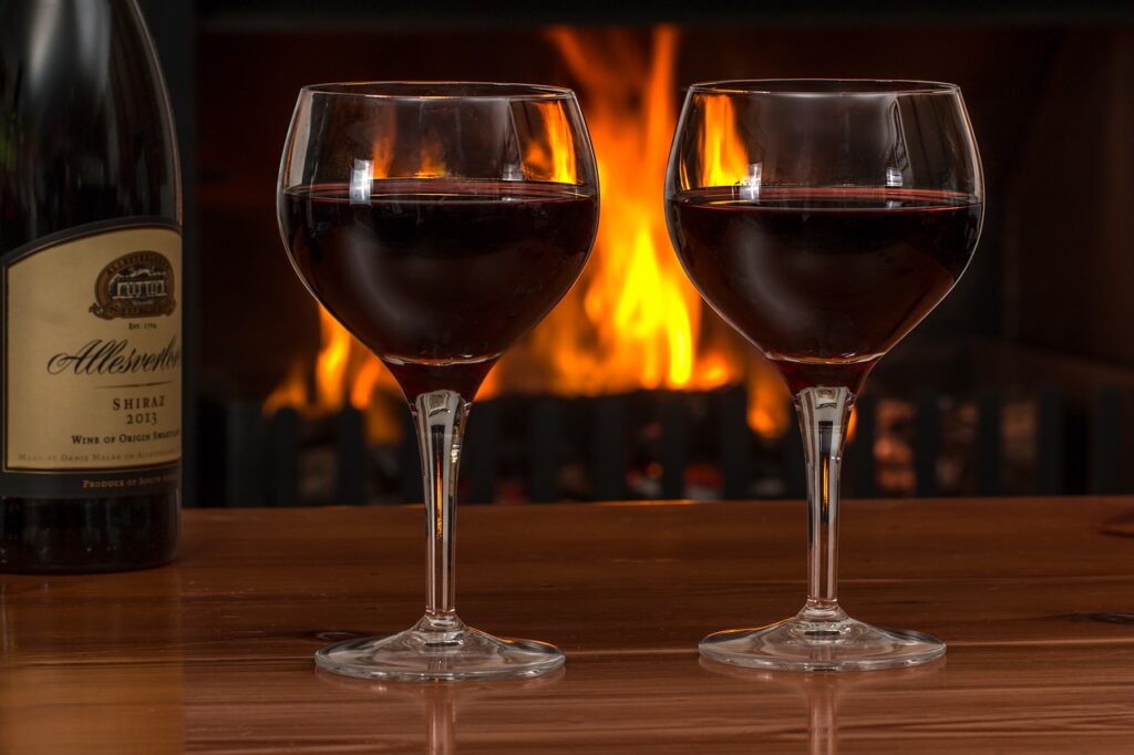 red wine glasses log fire red wine 2443699