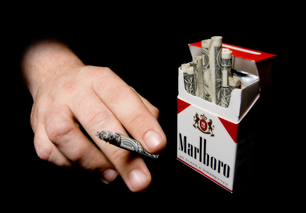 A man holding a Marlboro cigarette